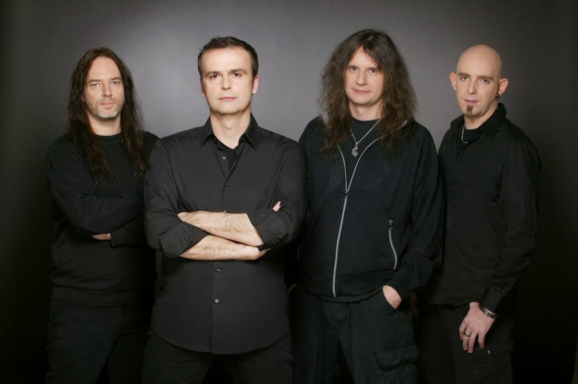 Marcus Siepen, Hansi Kürsch, André Olbrich e Frederik Ehmke (Blind Guardian) vestidos de preto em um fundo cinza